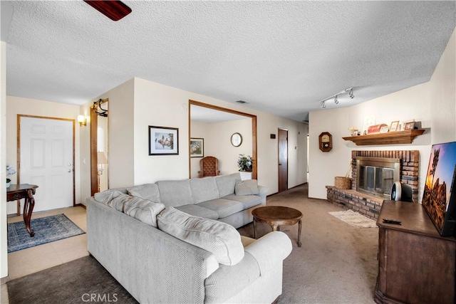 living room with light carpet, a textured ceiling, a fireplace, and rail lighting