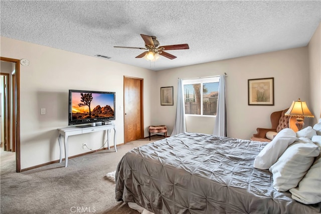 carpeted bedroom featuring ceiling fan and a textured ceiling