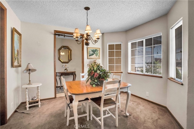 dining space featuring an inviting chandelier, carpet flooring, and a textured ceiling