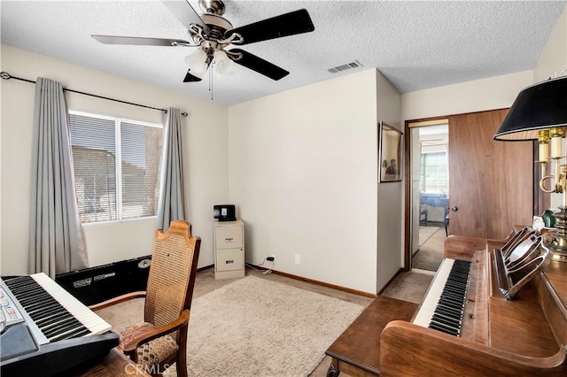 home office featuring ceiling fan and a textured ceiling