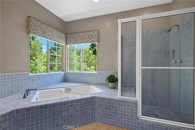 bathroom with tile patterned flooring and separate shower and tub