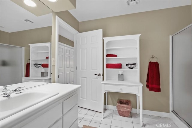 bathroom featuring an enclosed shower, tile patterned flooring, and sink