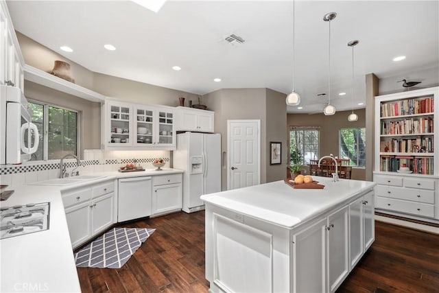 kitchen with white cabinetry, an island with sink, hanging light fixtures, and white appliances