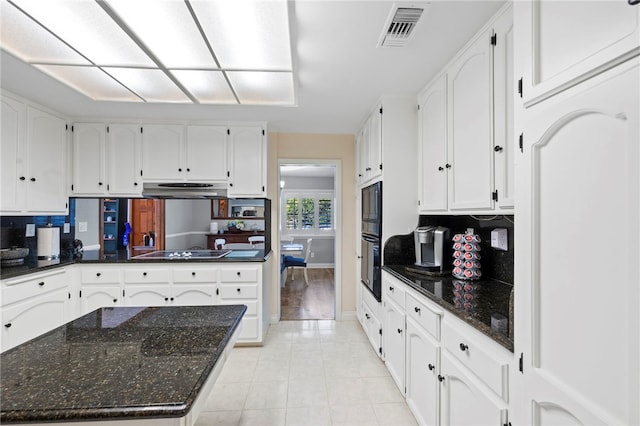 kitchen with black appliances, dark stone countertops, and white cabinetry