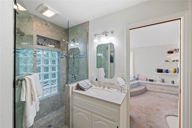 bathroom with tiled shower and vanity