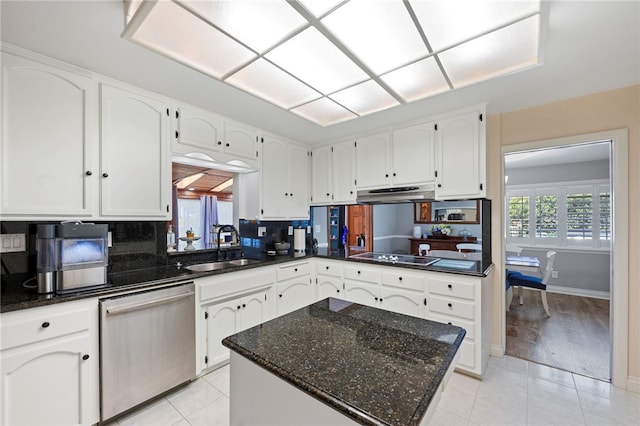 kitchen with backsplash, stainless steel dishwasher, sink, light tile patterned floors, and white cabinets