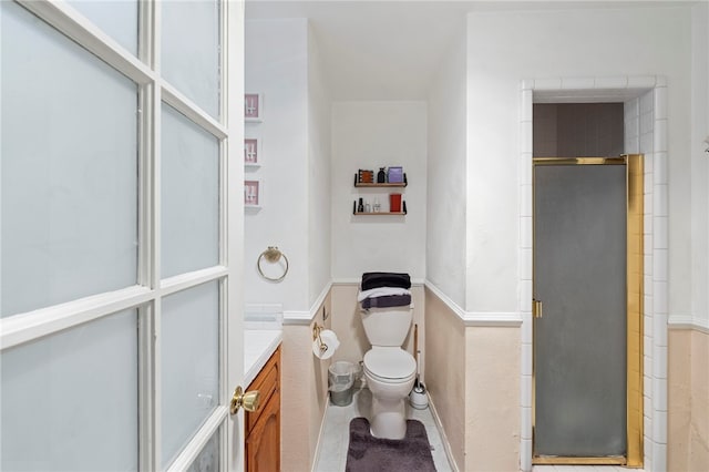 bathroom featuring tile patterned flooring, vanity, an enclosed shower, and toilet