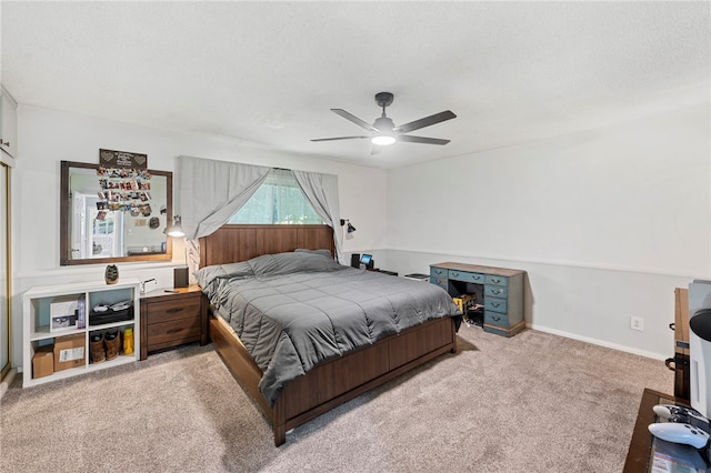 carpeted bedroom with ceiling fan and a textured ceiling