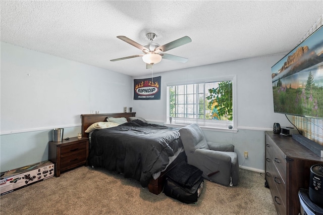 bedroom with ceiling fan, light carpet, and a textured ceiling