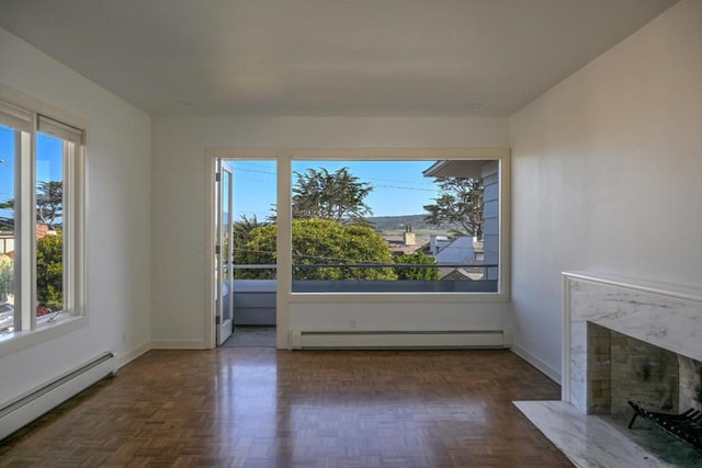 interior space featuring a baseboard heating unit, dark parquet flooring, and a fireplace