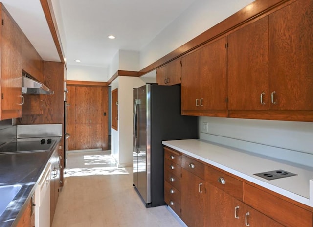 kitchen with extractor fan, stainless steel fridge, and electric cooktop