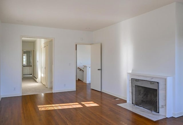 unfurnished living room featuring a fireplace, dark hardwood / wood-style flooring, and a baseboard radiator