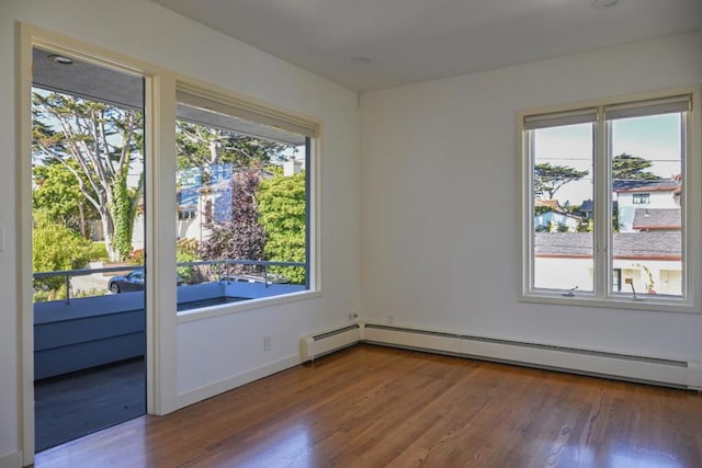 spare room with a baseboard heating unit and hardwood / wood-style flooring