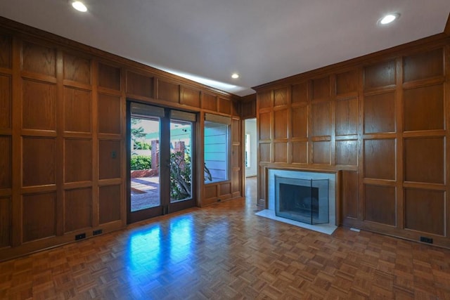 unfurnished living room with dark parquet floors and wood walls