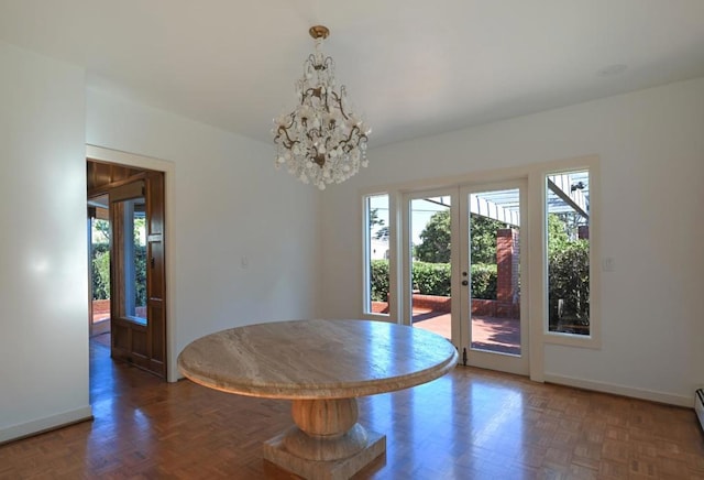 unfurnished dining area featuring an inviting chandelier, a baseboard radiator, and dark parquet floors