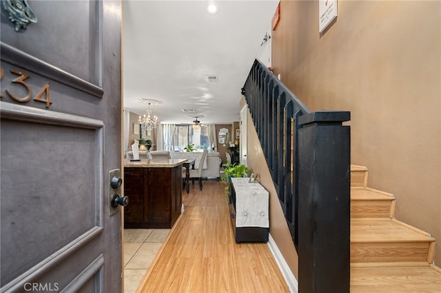 entrance foyer with light wood-type flooring and a chandelier