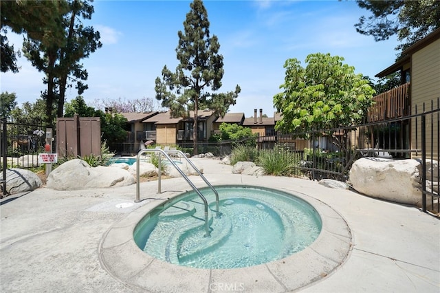 view of pool featuring a community hot tub and a patio area