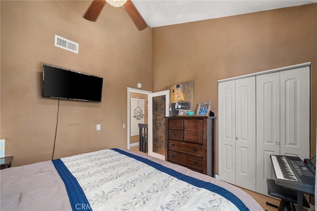 bedroom featuring high vaulted ceiling, a closet, ceiling fan, and hardwood / wood-style floors