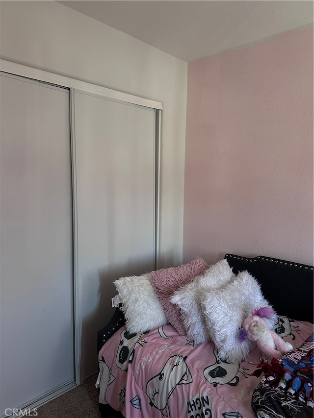 bedroom featuring dark carpet and a closet