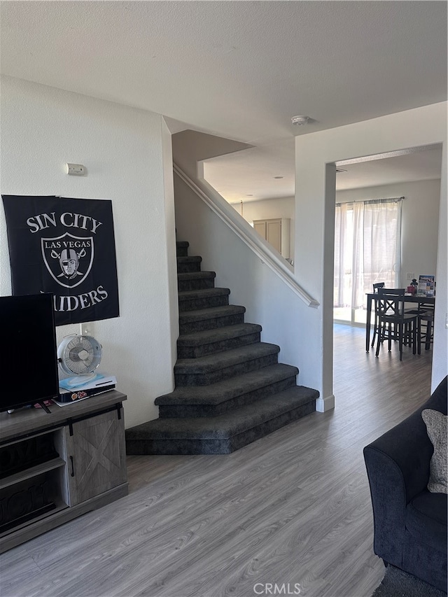 staircase featuring wood-type flooring and a textured ceiling