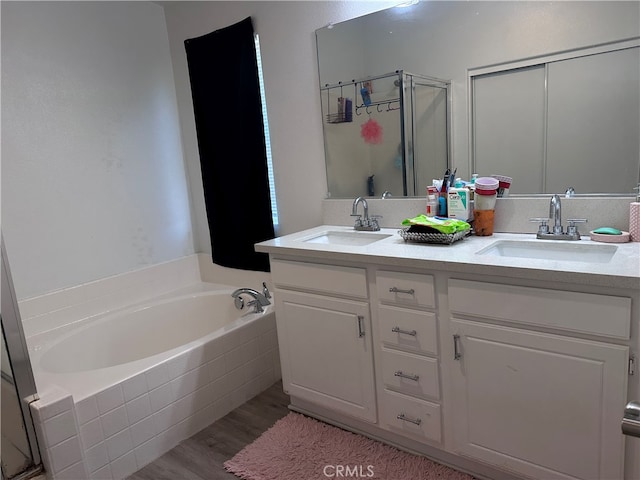 bathroom with hardwood / wood-style floors, vanity, and separate shower and tub