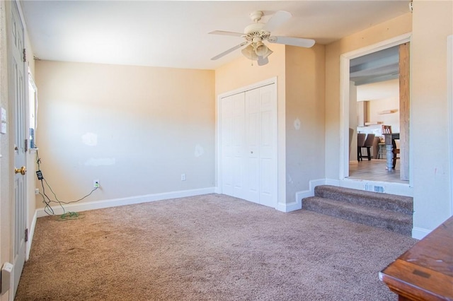 unfurnished bedroom with a closet, a ceiling fan, baseboards, and carpet