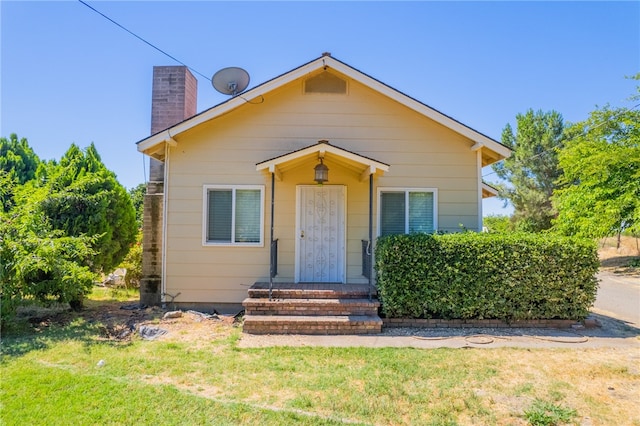 bungalow-style home featuring a front lawn