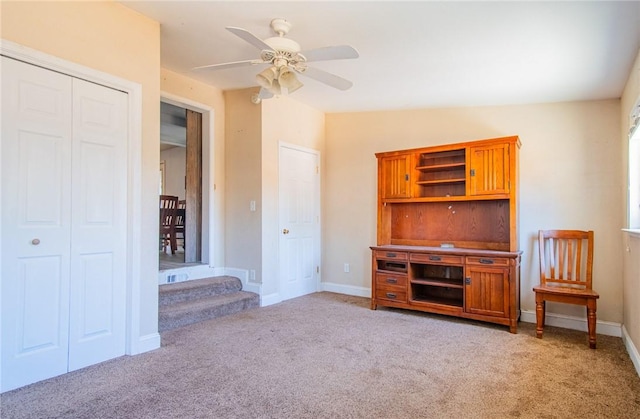 unfurnished living room with baseboards, stairway, a ceiling fan, lofted ceiling, and light colored carpet