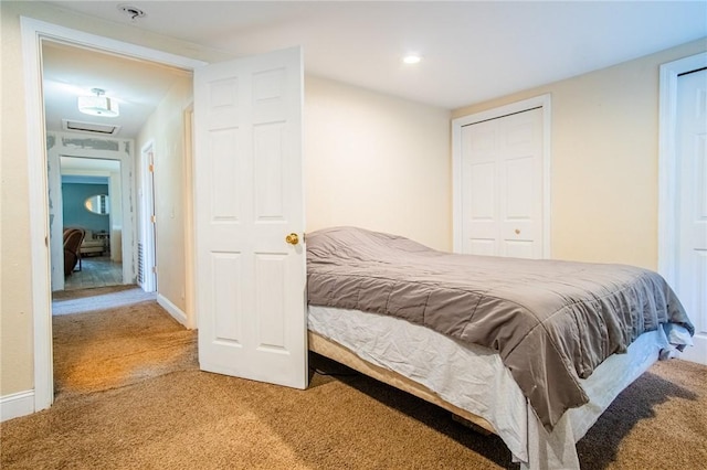 carpeted bedroom with attic access and baseboards