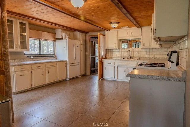 kitchen with stove, sink, light tile patterned floors, white refrigerator, and wooden ceiling