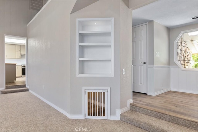 hallway featuring built in features and light hardwood / wood-style floors