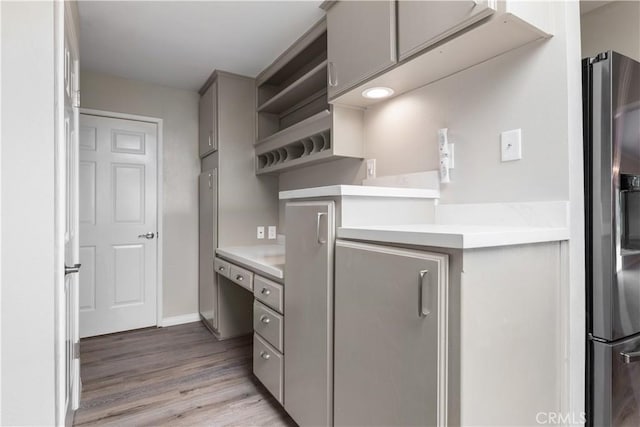 kitchen featuring gray cabinets, stainless steel fridge with ice dispenser, and light hardwood / wood-style flooring