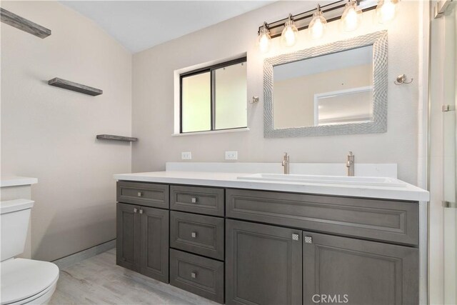 bathroom with vanity, toilet, and lofted ceiling