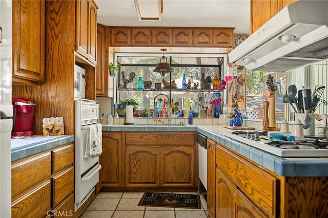 kitchen featuring sink, extractor fan, a wealth of natural light, and tile counters