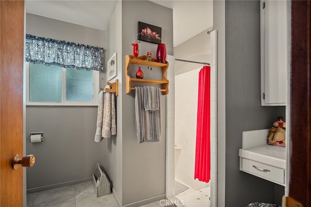 bathroom with curtained shower and tile patterned flooring