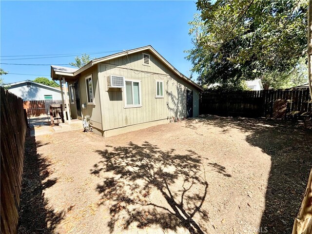 back of property featuring a patio and an AC wall unit