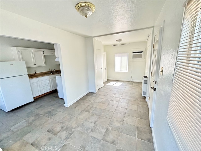 interior space with sink, a wall mounted AC, and a textured ceiling