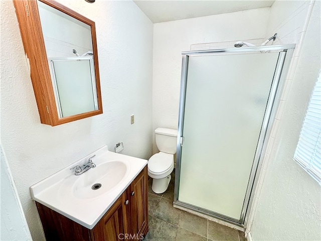 bathroom with vanity, a shower with shower door, and toilet