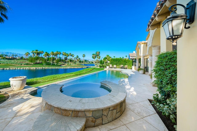 view of pool featuring a water view, a patio area, and an in ground hot tub