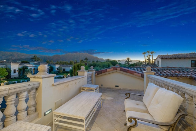 patio terrace at dusk featuring a mountain view