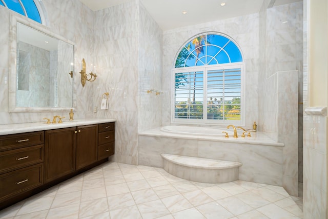 bathroom featuring tiled bath, vanity, tile walls, and tile patterned floors