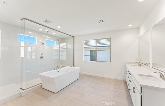 bathroom featuring plus walk in shower and vanity