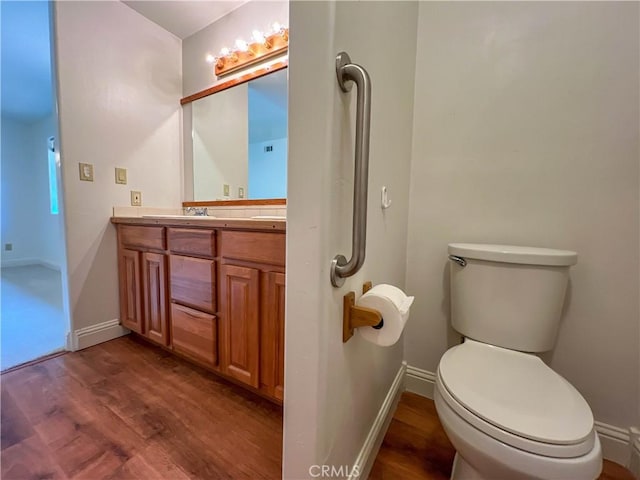 bathroom featuring vanity, hardwood / wood-style floors, and toilet