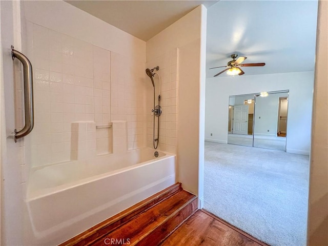 bathroom with ceiling fan, washtub / shower combination, and wood-type flooring