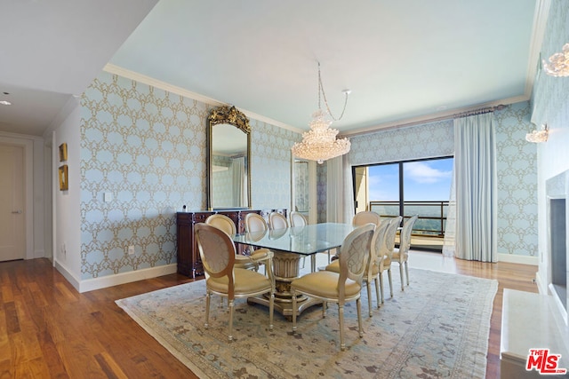 dining area featuring crown molding, hardwood / wood-style floors, and a notable chandelier