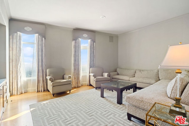 living room featuring ornamental molding, light hardwood / wood-style flooring, and a wealth of natural light