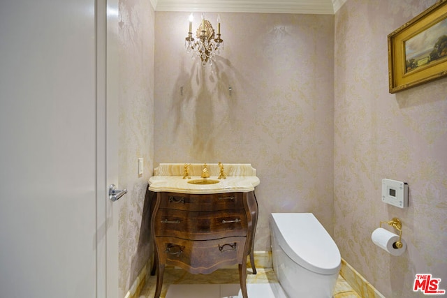 bathroom with vanity, crown molding, and toilet