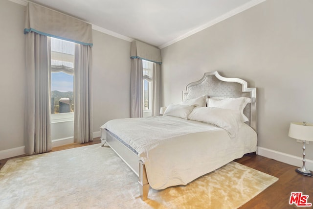 bedroom with hardwood / wood-style flooring and crown molding