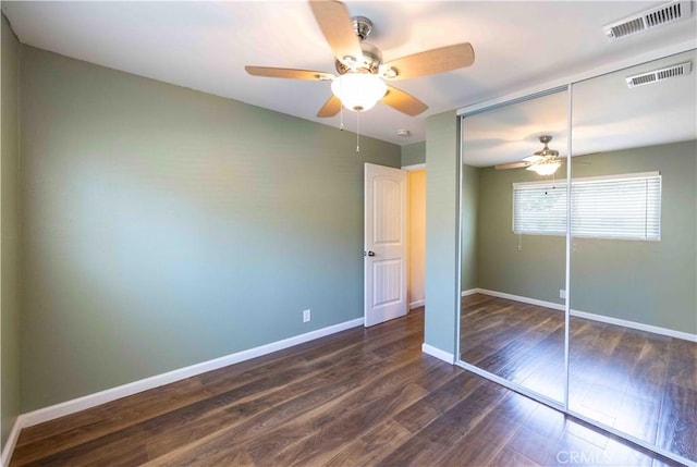 unfurnished bedroom featuring a closet, dark hardwood / wood-style flooring, and ceiling fan