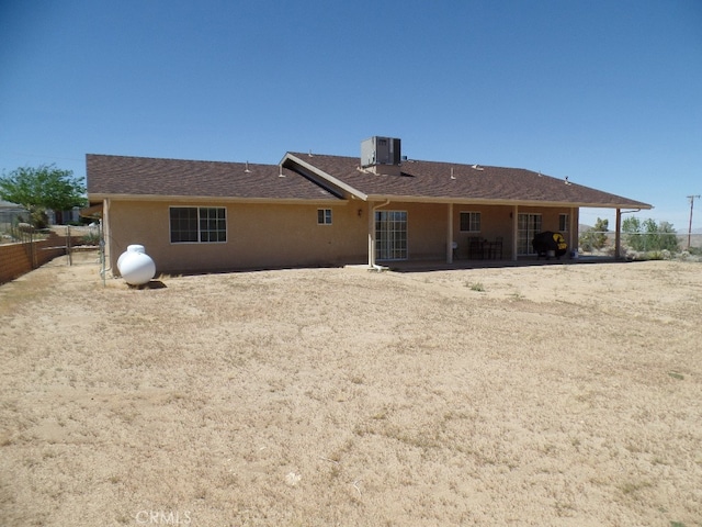 rear view of property with central AC unit and a patio